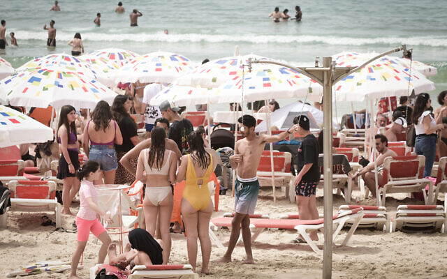Israelis crowd the beach in Tel Aviv on a hot day, during the Passover holiday. April 9, 2023. (Avshalom Sassoni/FLASH90)