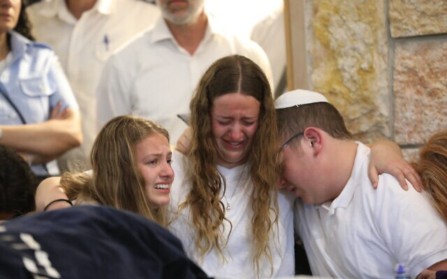 The family of Maia and Rina Dee mourn during the sisters' funeral in Kfar Etzion on April 9, 2023. (Noam Revkin Fenton/FLASH90)