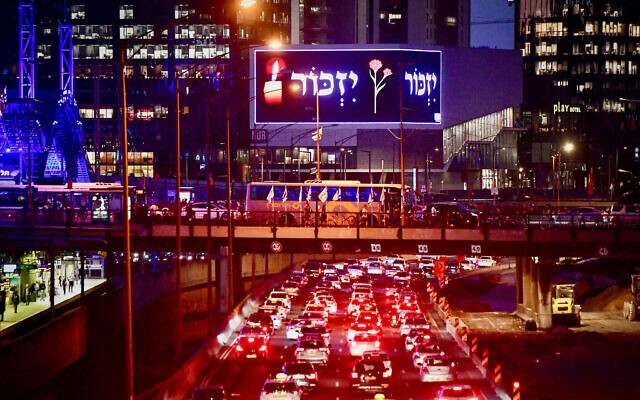People stand still on Tel Aviv's Ayalon Highway as a siren blares across Israel, marking Memorial Day to commemorate fallen Israeli soldiers and victims of terror, April 24, 2023. (Avshalom Sassoni/Flash90)