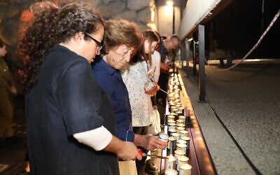 Visitors at Yad Vashem in Jerusalem light memorial candles dedicated to individuals killed in the Holocaust, April 17, 2023. (Yad Vashem)