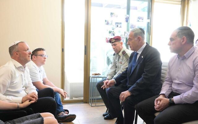 Prime Minister Benjamin Netanyahu with Rabbi Leo Dee, who lost his wife and two daughters in a terror attack, during a shiva visit to Efrat on April 16, 2023. (Amos Ben-Gershom/GPO)