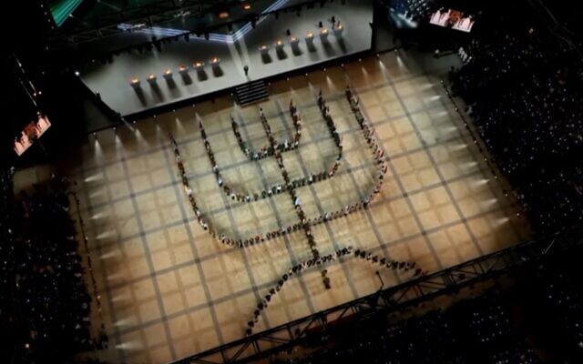 Participants in Israel's 75th Independence Day opening gala on Mt. Herzl in Jerusalem form the shape of the national menorah symbol, April 25, 2023 (GPO screenshot)