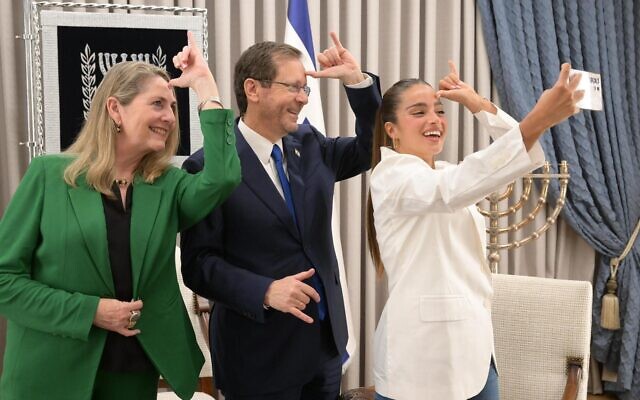 Singer Noa Kirel (right) poses for a selfie while making the 'unicorn' symbol with President Isaac Herzog and his wife, Michal, ahead of Kirel's departure to represent Israel at the Eurovision with the song 'Unicorn.' (Amos Ben Gershom/GPO)