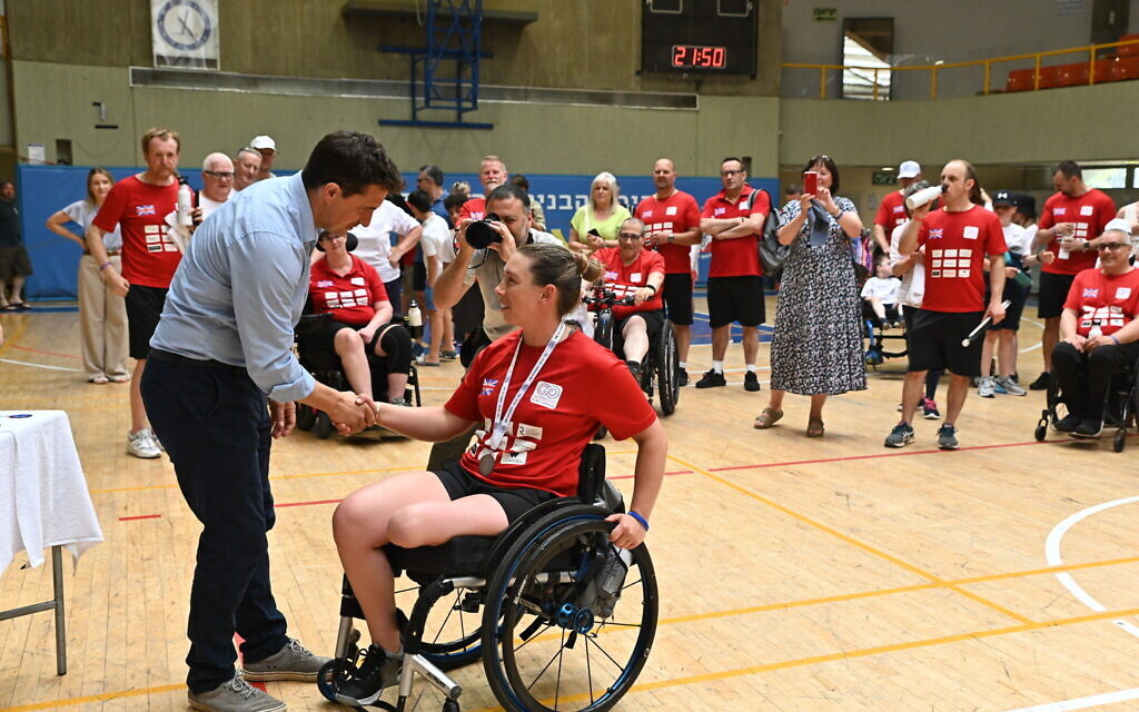 Johnny Mercer, the Minister for Veteran's Affairs in the British Parliament, congratulates a medalist in the crossfit event at the 3rd Veterans Games in Tel Aviv on May 29, 2023. (courtesy Beit HaLohem UK)