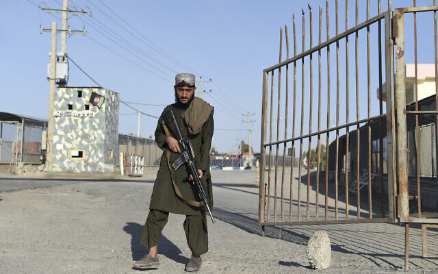 File: A Taliban fighter stands guard at the entrance gate of Afghan-Iran border crossing bridge in Zaranj, February 18, 2022. (Wakil Kohsar/AFP)