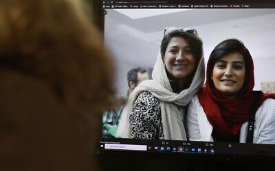 A woman looks at a picture of Iranian reporters Niloufar Hamedi (left) and Elahe Mohammadi posted on twitter, in Nicosia on November 2, 2022. (Christina ASSI / AFP)