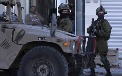 File: Israeli soldiers stand guard at the Jit junction, west of Nablus, in the northern West Bank, after three Palestinian gunmen were killed during a shootout, on March 12, 2023. (Jaafar Ashtiyeh / AFP)