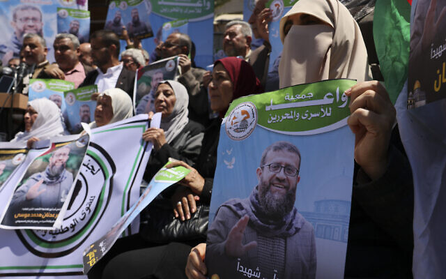 Palestinians in Gaza City hold portraits of Khader Adnan, a member of the Palestinian Islamic Jihad terror group who died in Israeli custody on May 2, 2023 after an 86-day hunger strike. (Mohammed Abed/AFP)