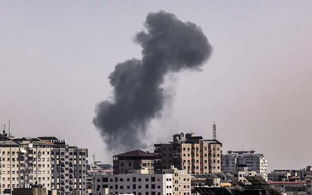A plume of smoke rises above buildings in Gaza City during an Israeli airstrike on May 11, 2023. (MOHAMMED ABED/AFP)
