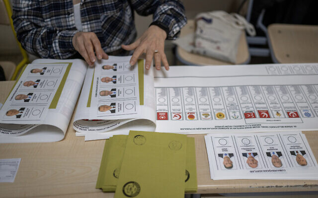 A woman prepares ballot papers and envelopes for people to cast their votes in Ankara on May 14, 2023, during Turkey's presidential and parliamentary elections (BULENT KILIC / AFP)