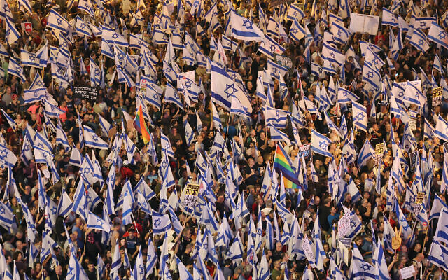 Protesters lift flags during a rally protesting the government's judicial overhaul plans in Tel Aviv on May 27, 2023. (JACK GUEZ/AFP)