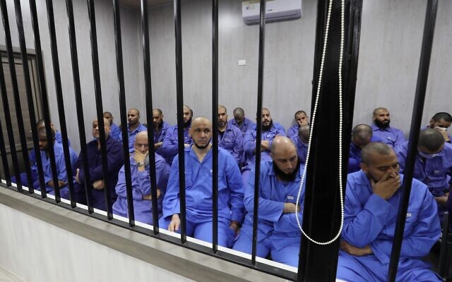 Jihadists accused of being members of the Islamic State (IS) group sit in the defendant booth during their trial, in the northwestern Libyan city of Misrata on May 29, 2023. (Mahmud Turkia / AFP)