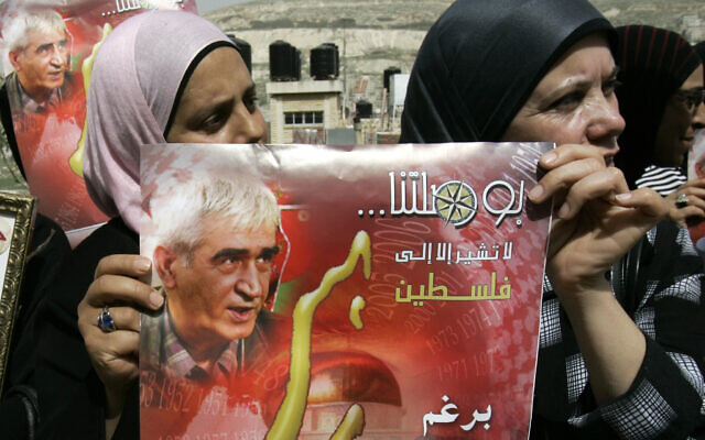 Palestinian supporters of the Popular Front for the Liberation of Palestine (PFLP) hold posters of the party's leader Ahmad Saadat, who is currently jailed in Israel, as they call for his release of during a protest in the West Bank city of Nablus, March 15, 2010. The Arabic text on the poster reads "Our compass doesn't point anywhere except to Palestine." (AP Photo/Nasser Ishtayeh)