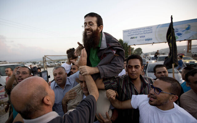 FILE - Khader Adnan, center, is greeted by Palestinians after his release from an Israeli prison in the West Bank village of Arrabeh near Jenin, July 12, 2015 (AP Photo/Majdi Mohammed, File)