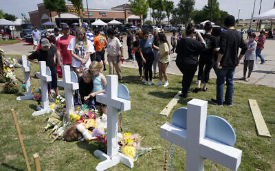 People look on at a makeshift memorial by the mall where several people were killed in Saturday's mass shooting, Monday, May 8, 2023, in Allen, Texas. (AP Photo/Tony Gutierrez)