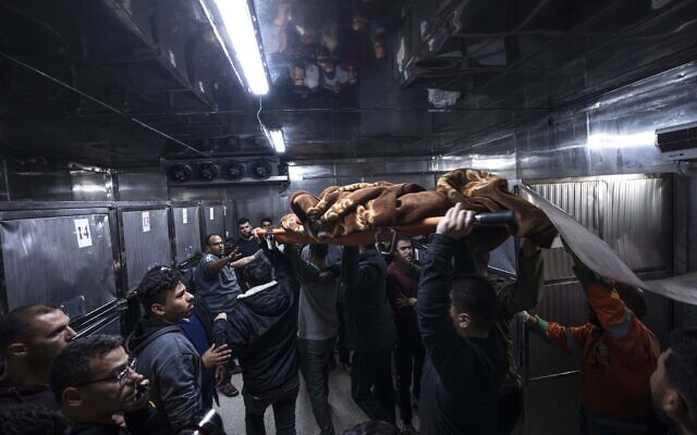 The body of a Palestinian killed in an Israeli airstrike, is carried into the morgue of Al-Shifa Hospital (AP Photo/Fatima Shbair)