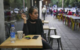 A woman sits in the alfresco dining area of a cafe at the Tajrish commercial district without wearing her mandatory Islamic headscarf in northern Tehran, Iran, April 29, 2023. (AP Photo/Vahid Salemi)