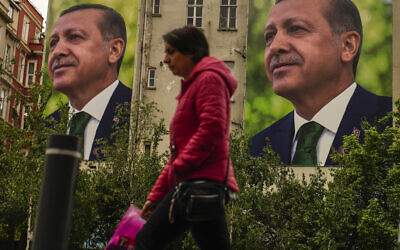 A person walks past billboards of Turkish President and People's Alliance's presidential candidate Recep Tayyip Erdogan a day after the presidential election day, in Istanbul, Turkey, May 15, 2023. (Emrah Gurel/AP)