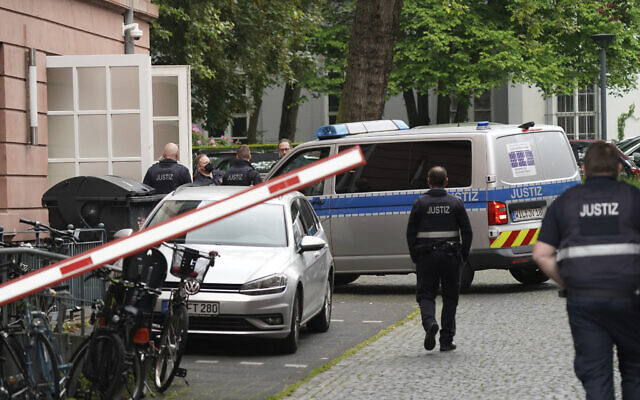 Judiciary vans, each carrying defendants, drive in a courtyard before the start of the trial against members of the 'United Patriots' group at the Higher Regional Court in Koblenz, Germany, May 17, 2023. (Sebastian Gollnow/dpa via AP)