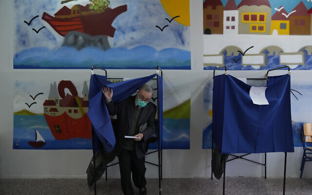 A man leaves the voting booth as he's votes at a polling station in Athens, Greece, May 21, 2023. (Thanassis Stavrakis/AP)