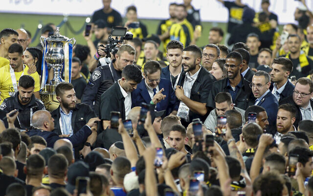 President Isaac Herzog (center) is surrounded by security on the field as fans of the Beitar Jerusalem soccer club rushed the field after their team won the State Cup finals in Haifa, May 23, 2023. (AP Photo/Alain Schieber)