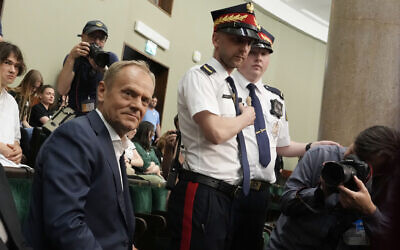 Poland's opposition leader and former prime minister Donald Tusk watches lawmakers vote to approve a contentious draft law in parliament in Warsaw, Poland, May 26, 2023. (AP Photo/Czarek Sokolowski)