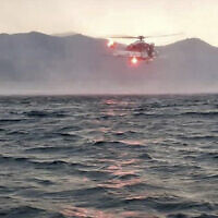 In this image released by the Italian firefighters, a helicopter searches for missing passengers after a tourist boat capsized in a storm on Italy's Lago Maggiore in the northern Lombardy region, May 28, 2023. (Vigili Del Fuoco via AP)