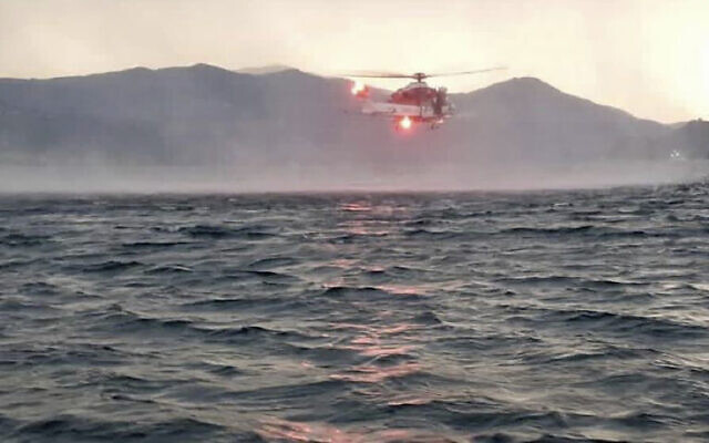 In this image released by the Italian firefighters, a helicopter searches for missing passengers after a tourist boat capsized in a storm on Italy's Lago Maggiore in the northern Lombardy region, May 28, 2023 (Vigili Del Fuoco via AP)