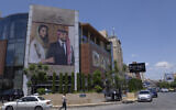 A poster with pictures of Jordan's Crown Prince Hussein and his fiancee, Saudi architect Rajwa Alseif hangs at the front of a building in Amman, Jordan, May 30, 2023. (Nasser Nasser/AP)