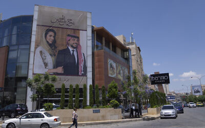 A poster with pictures of Jordan's Crown Prince Hussein and his fiancee, Saudi architect Rajwa Alseif hangs at the front of a building in Amman, Jordan, May 30, 2023. (Nasser Nasser/AP)
