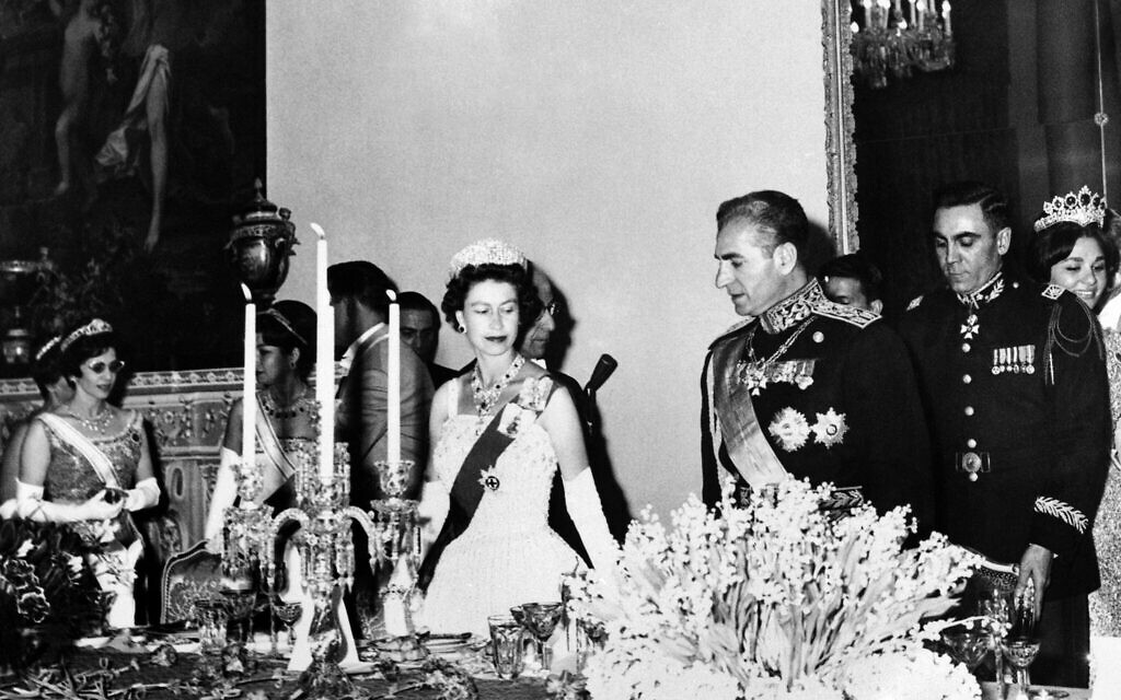 Britain's Queen Elizabeth II and the Shah Mohammed Reza Pahlevi of Iran take their seats at the banquet the Shah gave in honor of the Queen at the Golestan Palace in Tehran, Iran on March 2, 1961. Queen Farah Pahlevi is visible in right background. (AP Photo)