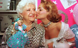 Barbie doll creator Ruth Handler, left, gets a kiss from Kristi Cooke, an actress dressed as a Barbie doll, during the 35th birthday celebration for the doll at FAO Schwarz in New York City on March 9, 1994. (AP Photo/Robert Clark)