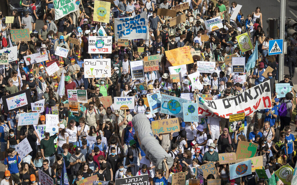 People holding banners march to demand world leaders to take action in reversing climate change and stop the use of fossil fuels during a rally in Tel Aviv, Israel, Friday, Oct. 29, 2021.  (AP Photo/Ariel Schalit)