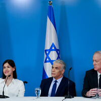 Then-prime minister Yair Lapid, center, then-Defense Minister Benny Gantz, right, and then-Energy Minister Karine Elharrar hold a press conference on the maritime border deal with Lebanon at the Prime Minister's office in Jerusalem, October 12, 2022. (Olivier Fitoussi/Flash90)