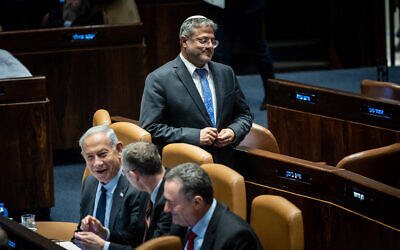 National Security Minister Itamar Ben Gvir walks past Prime Minister Benjamin Netanyahu (seated, left), Justice Minister Yariv Levin and Infrastructure and Energy Minister Israel Katz in the Knesset plenum on May 1, 2023. (Yonatan Sindel/Flash90)