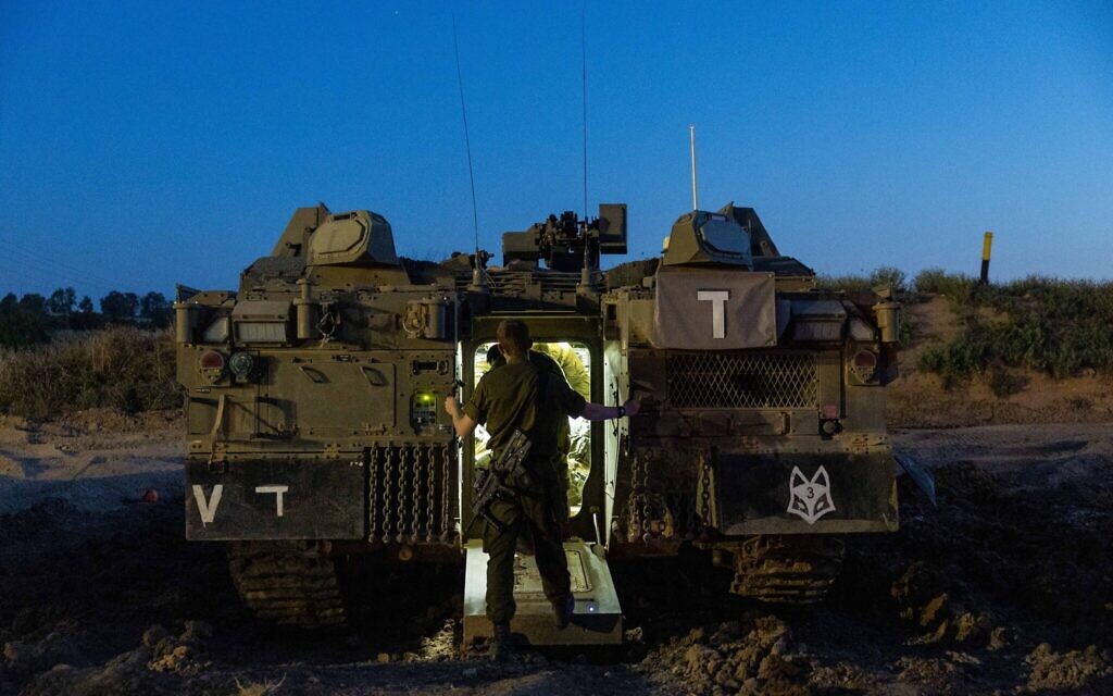 A soldier enters an armored vehicle at a staging area for troops on the border with Gaza, on May 2, 2023. (Yonatan Sindel/Flash90)
