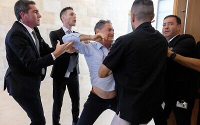 Hizky Sivak of the Emek Hefer Regional Council is taken out by Knesset guards from a Finance Committee meeting and a vote on the Arnona Fund at the Knesset in Jerusalem, on May 15, 2023. (Yonatan Sindel/Flash90)
