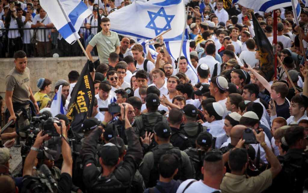 Young Jewish men hold Israeli flags and flags of the racist, far-right Lehava organization at Damascus Gate in Jerusalem's Old City, during Jerusalem Day celebrations, May 18, 2023. (Jamal Awad/Flash90)