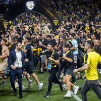 Beitar Jerusalem fans storm the field at Sammy Ofer Stadium in Haifa, May 23, 2023. (Oren Ben Hakoon/Flash90)