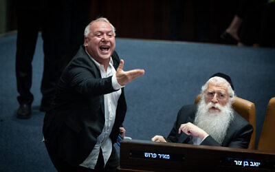 Likud MK David Amsalem (left) reacts during a discussion and a vote on the state budget at the Knesset in Jerusalem, May 23, 2023. (Yonatan Sindel/Flash90)