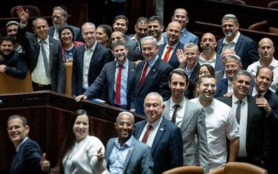 Prime Minister Benjamin Netanyahu, with Finance Minister Bezalel Smotrich at his side, and other coalition ministers and MKs celebrate the passage of the state budget in the Knesset, May 23, 2023. (Yonatan Sindel/Flash90)