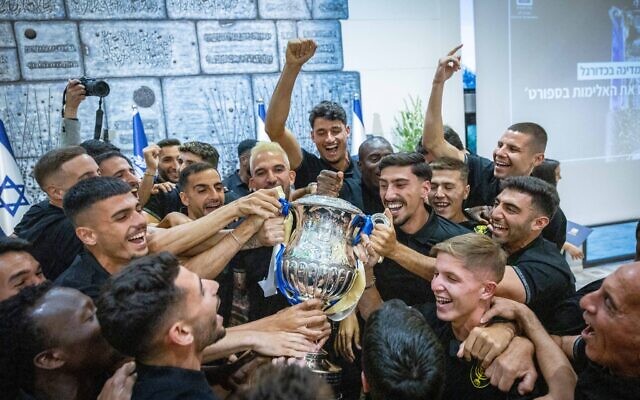 Beitar Jerusalem players celebrate with the State Cup after being presented with the trophy by President Isaac Herzog at the president's residence in Jerusalem on May 24, 2023. (Yonatan SIndel/Flash90)