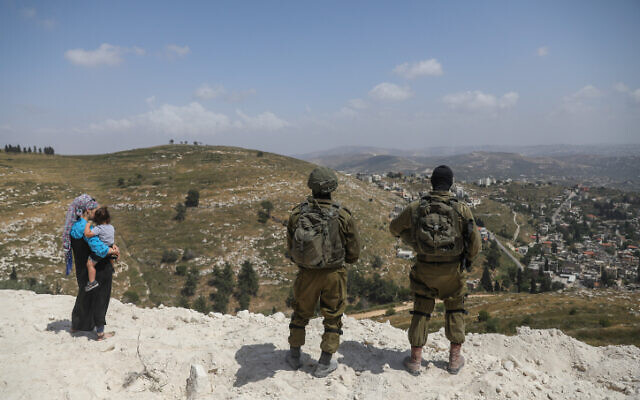Illustrative: Israeli soldiers stand guard at the West Bank outpost of Homesh on May 29, 2023. (Flash90)