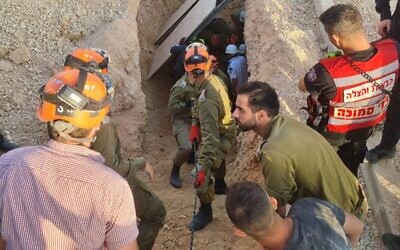IDF rescuers work to pull a pair of Palestinian construction workers from under collapsed rubble in the Neve Daniel settlement on May 31, 2023. (Israel Defense Forces)