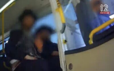 Screen capture from video of ultra-Orthodox men preventing a woman from boarding a bus in Ashdod due to her gender, May 7, 2023. (Channel 12. Used in accordance with Clause 27a of the Copyright Law)