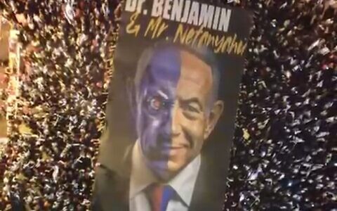 A large banner depicts Israeli Prime Minister Benjamin Netanyahu as Dr. Jekyll and Mr. Hyde in Tel Aviv, May 27, 2023. (Video screenshot)