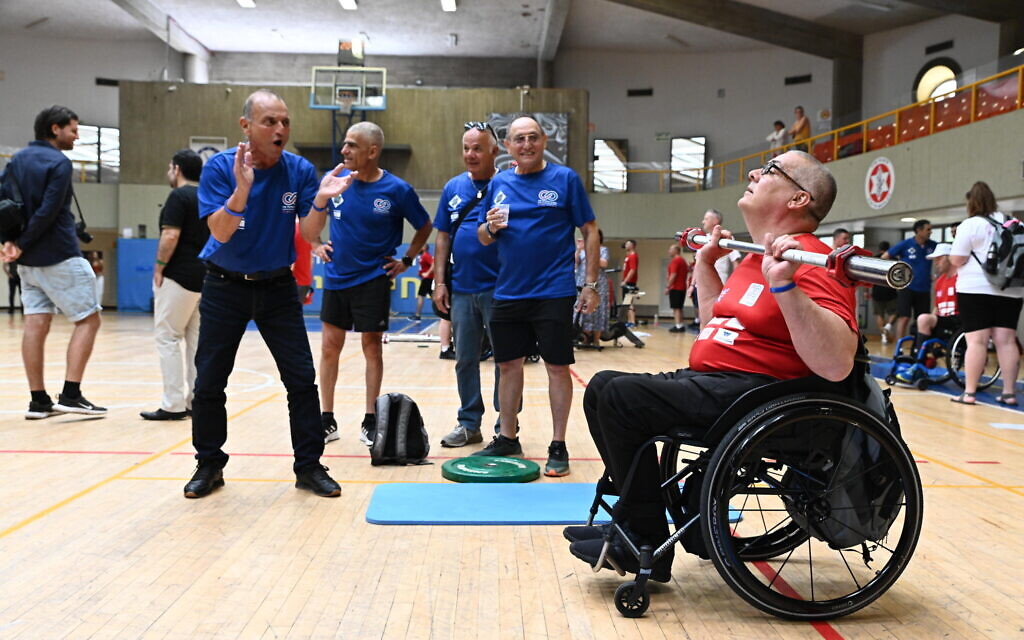 A British athlete is cheered on by Israeli staff and athletes during the 3rd Veterans Games in Tel Aviv on May 29, 2023. (courtesy Beit HaLohem UK)