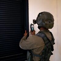 An Israeli soldier takes measurements at the home of Khaled Kharousha, accused of helping his father, a Hamas terrorist, in carrying out a deadly attack in Huwara, in the West Bank city of Nablus early May 13, 2023. (Israel Defense Forces)