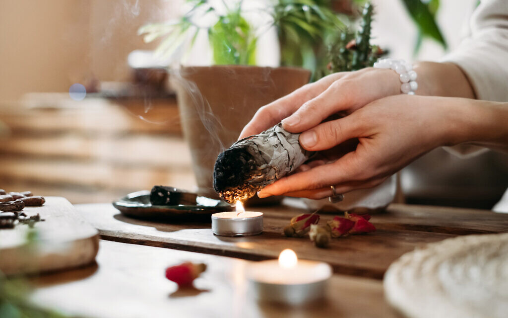 Woman hands burning white sage. (iStock photo/ ninelutsk)