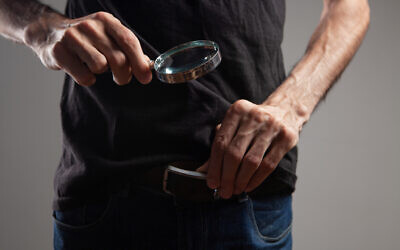 Illustrative: A man examines his pants with a magnifying glass (Juleta Martirosyan; iStock by Getty Images)